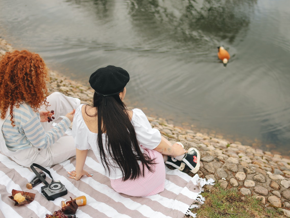 Deux filles assise profitant d’un pique-nique sur les Bords de Seine