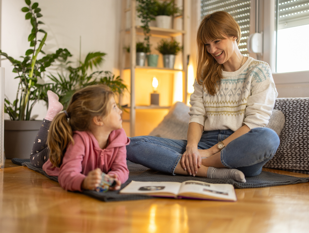 Mother and little daughter enjoying book together