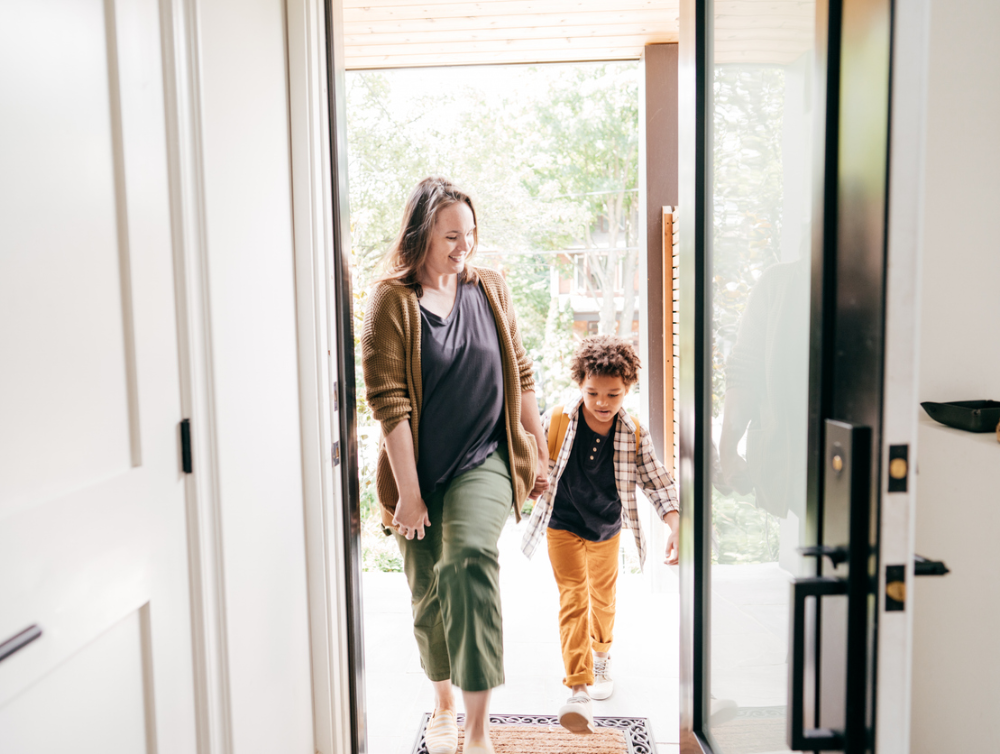 Maman et fils marchant à travers la porte ensemble. Moment de retour à l’école