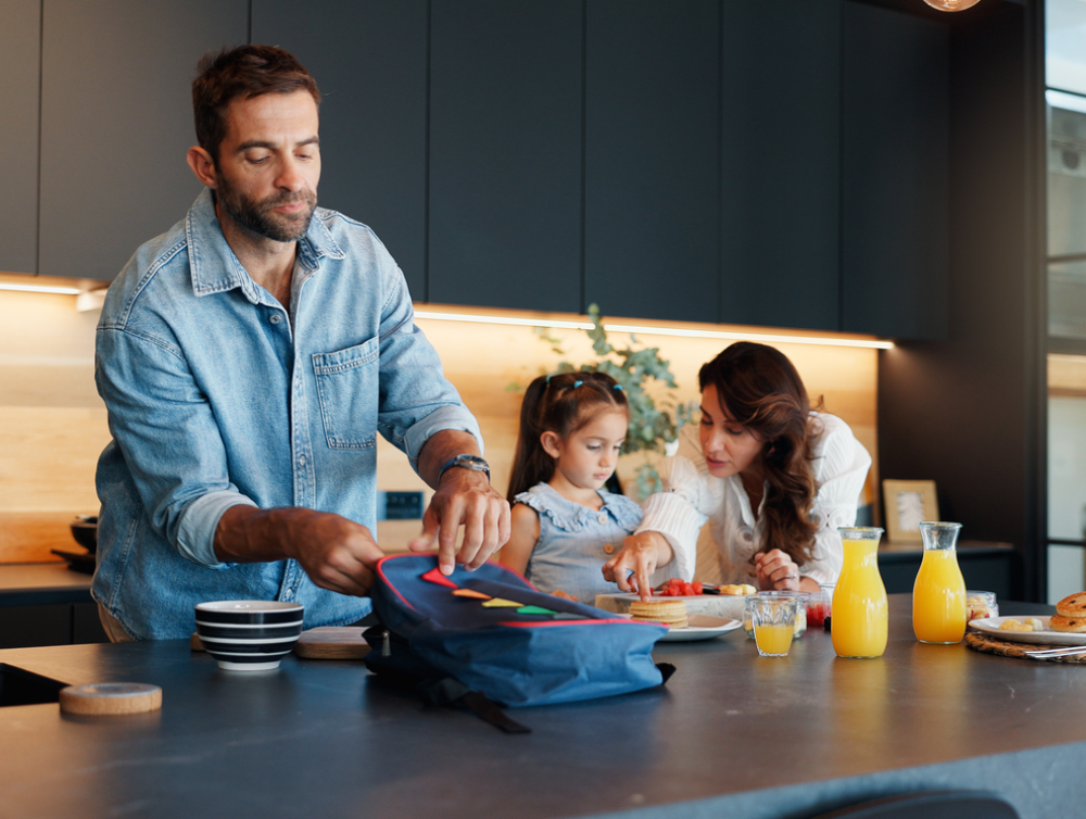 Parents, enfant et panier-repas dans la cuisine avec petit-déjeuner sain, préparation et retour à l’école. Mère, père et fille avec repas de famille, alimentation nutritionnelle et préparation pour la collation de la maternelle à la maison