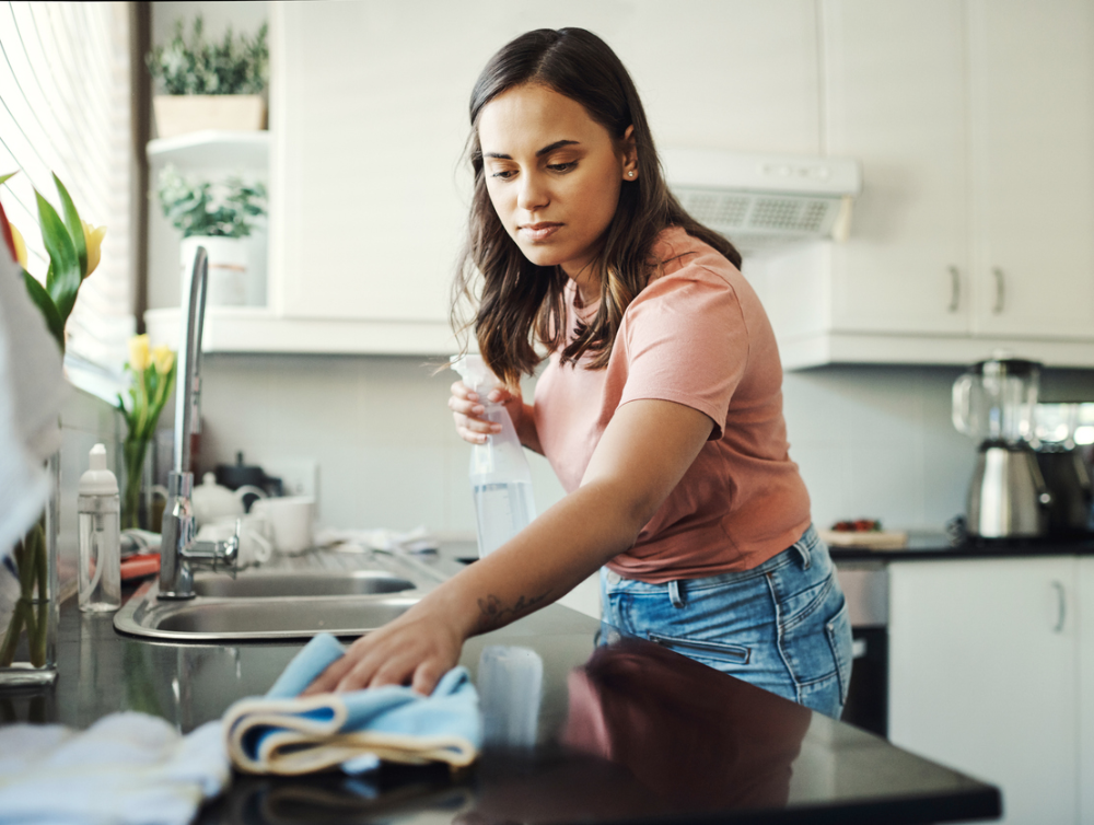 Photo d’une jolie jeune femme utilisant un chiffon pour nettoyer les comptoirs de la cuisine à la maison