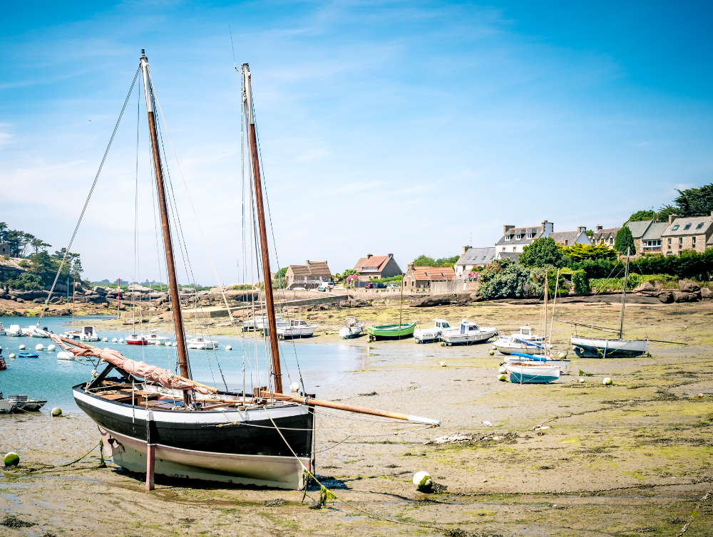 photo d’un voilier breton et de petits bateaux avec des maisons dans le fond pour le ménage à Perros-Guirec